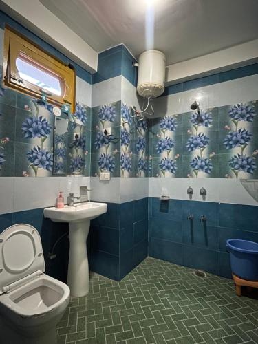 a bathroom with a toilet and a sink at Trippy Homestay in Kasol