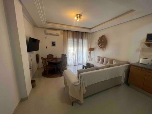 a living room with a couch and a table at Sousse Appartement avec terrasse in Chott Meriem