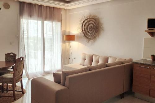 a living room with a couch and a table at Sousse Appartement avec terrasse in Chott Meriem