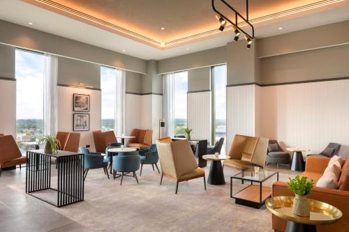 a lobby with tables and chairs and windows at Hilton Woking in Woking