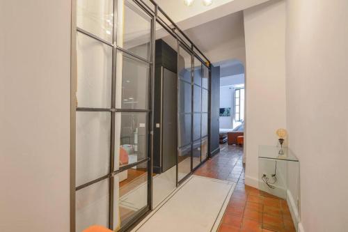 un couloir avec des fenêtres en verre et un salon dans l'établissement Élégant Appartement Standing à 3min du Cours Mirabeau, à Aix-en-Provence