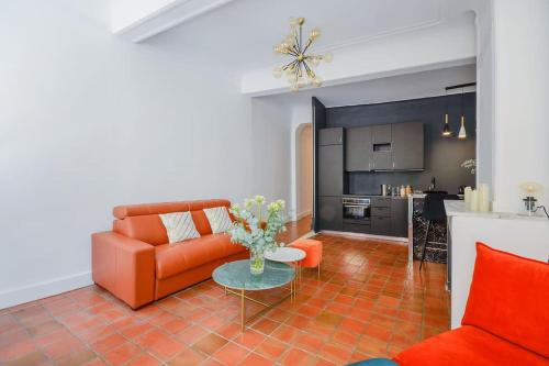 un salon avec un canapé orange et une table dans l'établissement Élégant Appartement Standing à 3min du Cours Mirabeau, à Aix-en-Provence