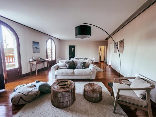 un salon avec un canapé blanc et une table dans l'établissement Les Basques, Vue et Acces directe à la plage, immense terrasse, place des landais Hossegor, quartier très animé, idéal pour un séjour entre amis, à Soorts-Hossegor