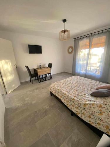 - une chambre avec 2 lits, une table et une télévision dans l'établissement Studio les fontaines, à Gréoux-les-Bains