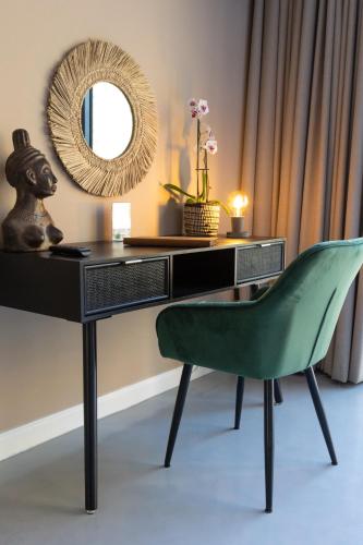 a desk with a green chair and a mirror at Marepe Mountain View in Kampersrus AH