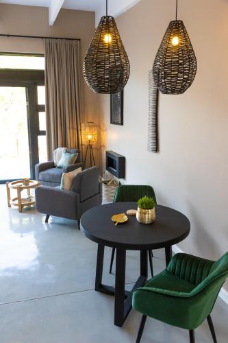 a living room with a table and green chairs at Marepe Mountain View in Kampersrus AH