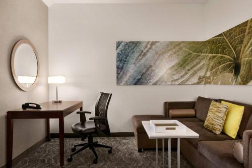 a living room with a couch and a desk at SpringHill Suites Dulles Airport in Sterling