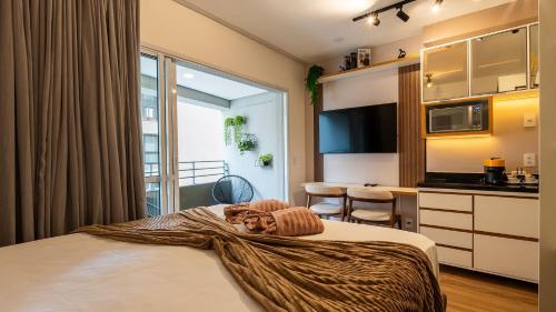 a bedroom with a bed and a kitchen with a table at By DH: Luxo e conforto em Perdizes, aos poucos minutos do Allianz parque in Sao Paulo