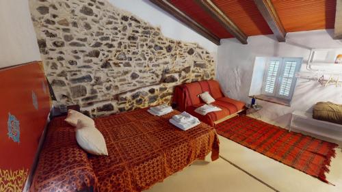 a bedroom with a bed and a stone wall at La Nueva Andalusí in Cazalla de la Sierra