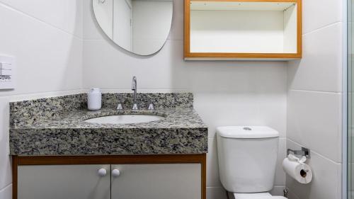 a bathroom with a sink and a toilet and a mirror at By DH: Luxo e conforto em Perdizes, aos poucos minutos do Allianz parque in Sao Paulo