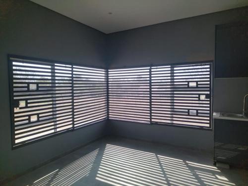 a room with two large windows with blinds at 114 Zinnia in Midrand