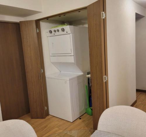 a kitchen with a refrigerator and a washer and dryer at Elegante apartamento cerca de Embajada de los EEUU y Cayala in Guatemala