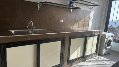 una cucina con lavello e lavatrice di VILLA AVEC PISCINE à NGAPAROU à 1 MIN DE LA PLAGE A PIED a Ngaparou