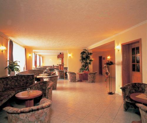 a lobby with chairs and tables in a hotel at Hotel Rügen Park KG in Gingst