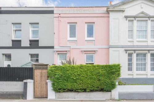 a pink house in front of some white houses at The Pink House in Torquay