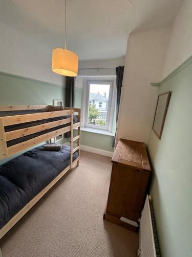 a bedroom with two bunk beds and a window at The Pink House in Torquay