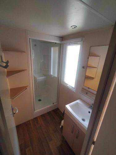 une salle de bain avec une douche, un lavabo et un miroir dans l'établissement Mobil-Home Location de Vacances, à Talmont-Saint-Hilaire