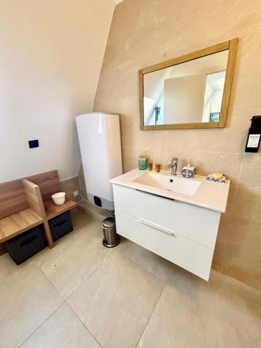 une salle de bain avec un lavabo et un miroir dans l'établissement Un été sans fin à Deauville, à Deauville
