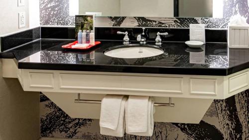 a bathroom with a sink with a black counter top at Williamsburg Lodge, Autograph Collection in Williamsburg