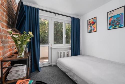 a bedroom with a bed and a window at Patro Apartament 2 Wrocław Centrum in Wrocław