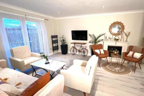a living room with white furniture and a fireplace at The Art Gallery Guest House - Newport Cozy 3-Bedroom Home in Newport