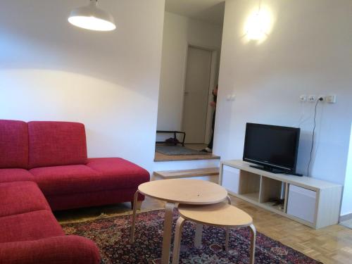 sala de estar con sofá rojo y mesa en Apartment Franc, en Kranjska Gora