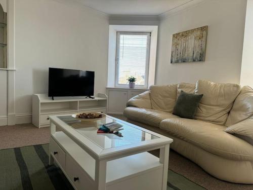 a living room with a couch and a coffee table at Town Centre Flat For Two Adults in Blairgowrie in Blairgowrie
