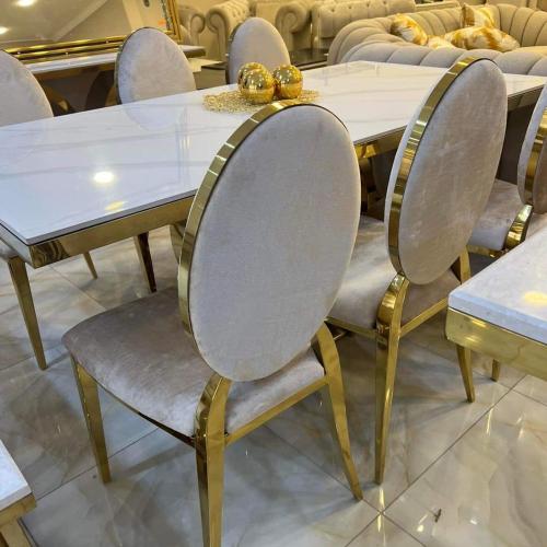 a dining room table with gold and white chairs at LES RÉSIDENCES DE DJIBRIL in Le Blanc-Mesnil