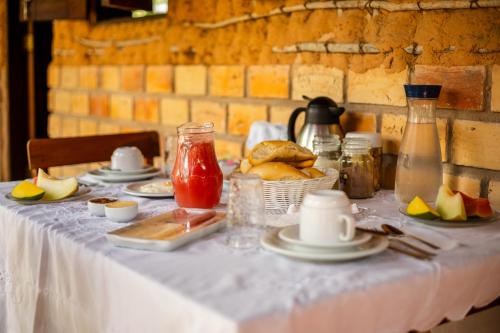 a table with a white table cloth with food on it at Pousada Chale Creoulo in Jericoacoara