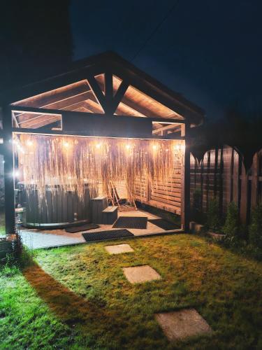 a pergola with lights in a yard at night at Domek Drwala k. Karpacza in Sosnówka