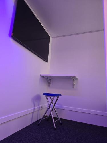 a purple room with a stool and a window at Modular Rooms in Madrid