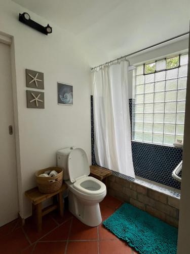 a bathroom with a toilet and a shower and a window at Villa NO&LO in Sainte-Anne