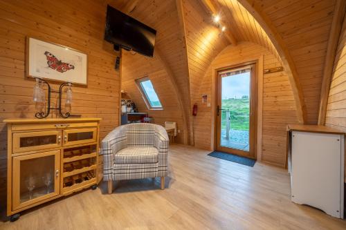 a living room with a tv and a chair at Borrett Escapes - Luxury Pods in Sedbergh