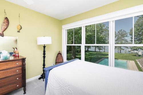 a bedroom with a bed and a large window at Baydream Believer in Saint Michaels