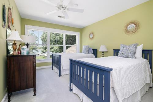 a bedroom with two beds and a window at Baydream Believer in Saint Michaels