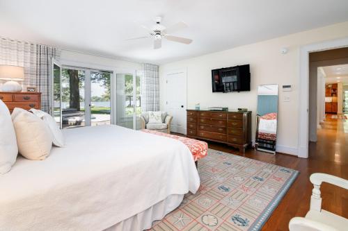 a bedroom with a white bed and a tv at Baydream Believer in Saint Michaels
