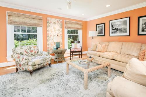 a living room with orange walls and a couch and a table at Baydream Believer in Saint Michaels