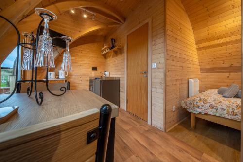 a room with a bed and a wooden wall at Borrett Escapes - Luxury Pods in Sedbergh