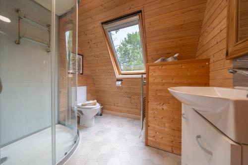 a bathroom with a toilet and a sink and a window at Borrett Escapes - Luxury Pods in Sedbergh