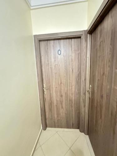a wooden door in a room with a tile floor at charming room close to Marrakech airport in Marrakech