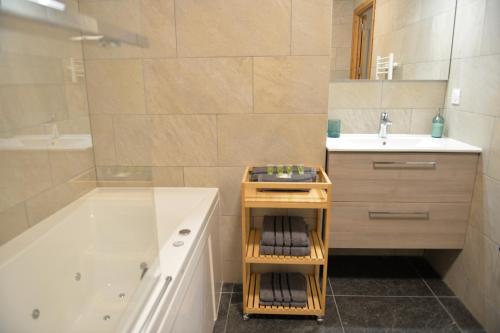 モントリオンにあるLe refuge de Montriondの浴槽と洗面台とバスタブを備えたバスルーム