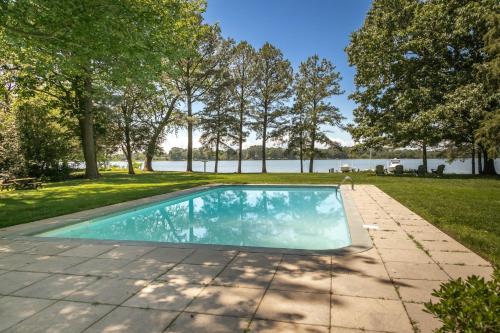 an image of a swimming pool in a yard with trees at Baydream Believer in Saint Michaels