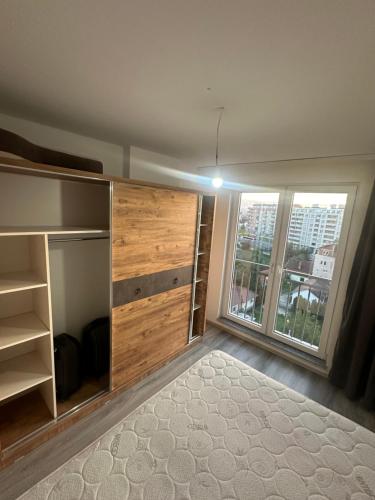 a bedroom with a large wooden closet with a window at Fushe kosove pristina daire otel apart in Kosovo Polje