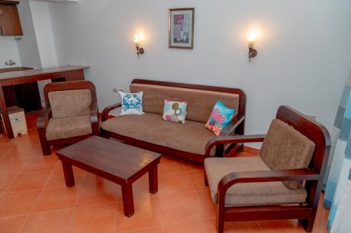 a living room with a couch and two chairs at Sea Life Apartments-hotel in Hurghada