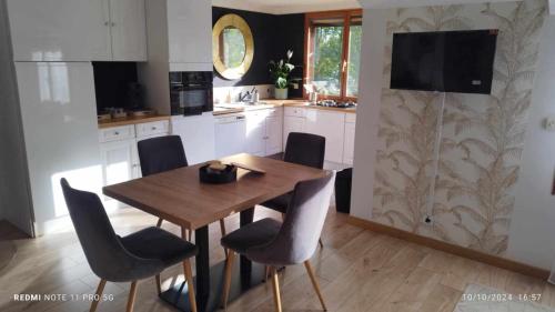 a kitchen with a wooden table and some chairs at Le chalet de l'amitié in Luché-Pringé