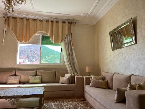 a living room with a couch and a window at شقة مفروشة تطل على طبيعة جميييلة in Ouazzane