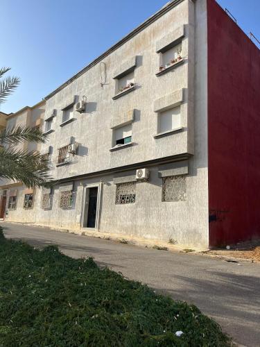 a concrete building with a red wall and a street at شقة مفروشة تطل على طبيعة جميييلة in Ouazzane