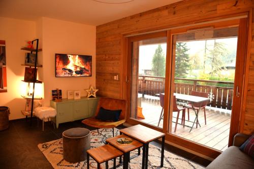 モントリオンにあるLe refuge de Montriondのリビングルーム(テーブルと椅子付きのバルコニー付)