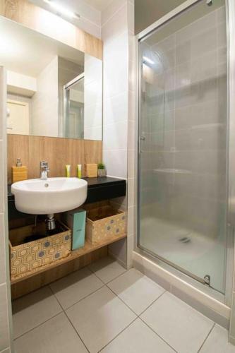 une salle de bain avec un lavabo et une douche dans l'établissement Le Tony Garnier Check in H24 wifi, à Lyon