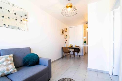 un salon avec un canapé bleu et une table dans l'établissement Le Tony Garnier Check in H24 wifi, à Lyon